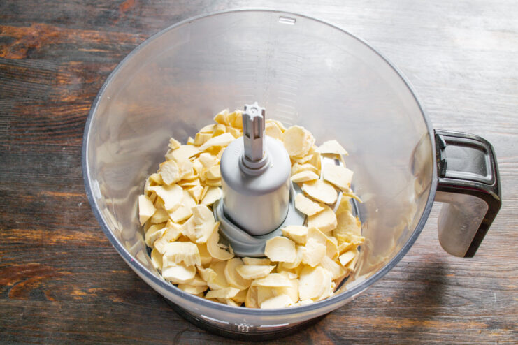 How to Grind Horseradish Root for Your Sauce Peeled horseradish roots being chopped into smaller pieces on a cutting board.