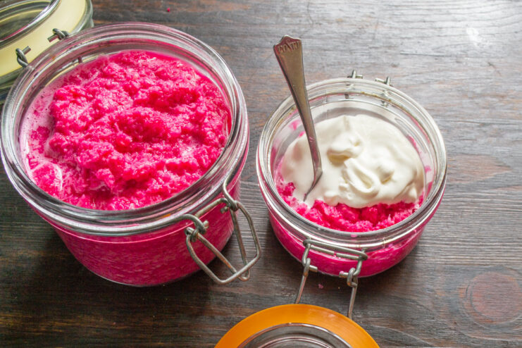 Finishing Touch: Mixing Horseradish with Creamy Smetana A bowl of pink horseradish sauce with a spoonful of creamy sour cream being added.