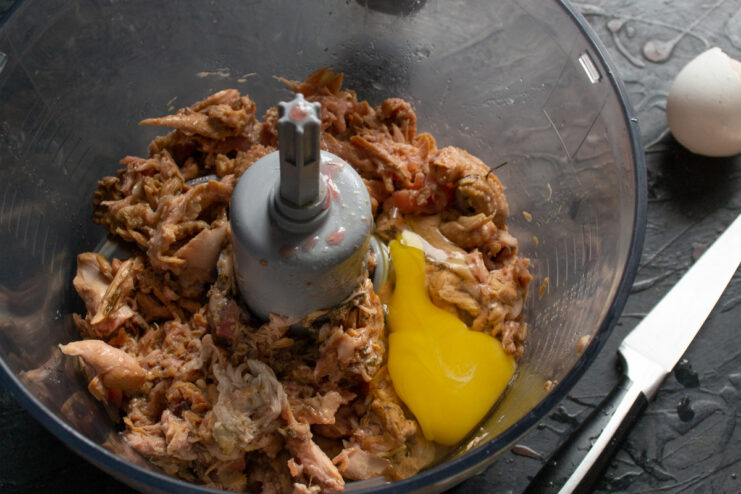 Adding Rich Chicken Broth for a Moist and Flavorful Pâté Strained chicken broth being poured into a blender with chicken meat.