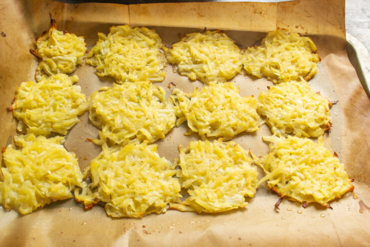 Baking Draniki Until Golden Brown in the Oven A baking sheet with draniki baking in the oven, turning golden brown.