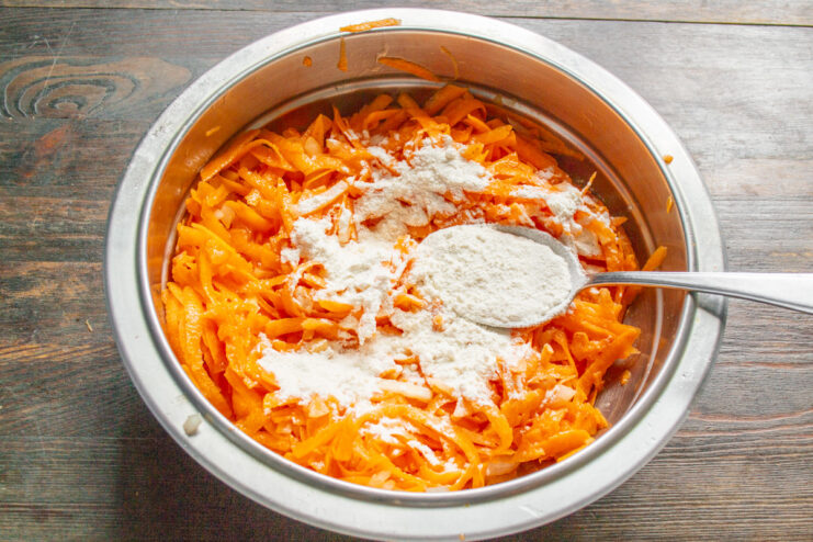 Adding Flour to the Sweet Potato Batter Adding two tablespoons of wheat flour to the sweet potato and egg mixture in a bowl.