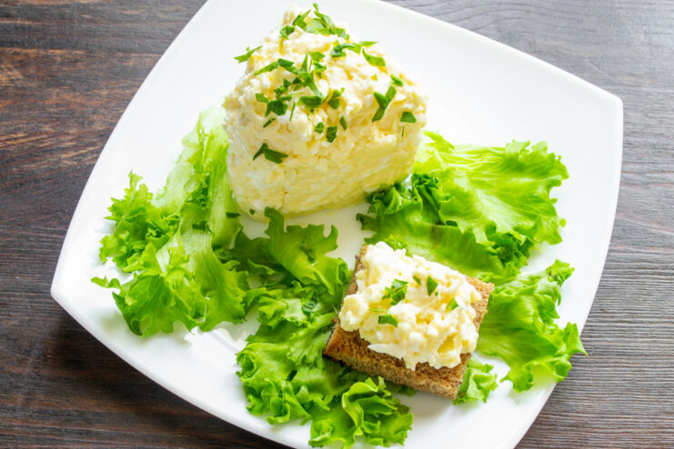 Garnishing the Finished Salad with Fresh Parsley The finished Jewish-style processed cheese salad, garnished with fresh parsley and served with toast.