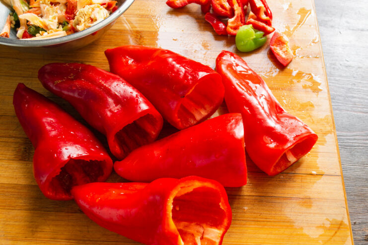 Rinsing Peppers Before Cooking Cleaned bell peppers being rinsed under running water in a colander.