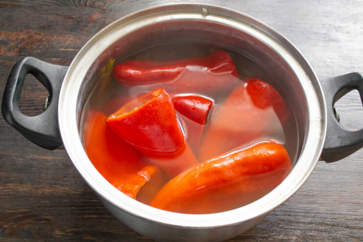 Blanching Peppers to Soften Them for Stuffing Bell peppers being blanched in a large pot of boiling water.