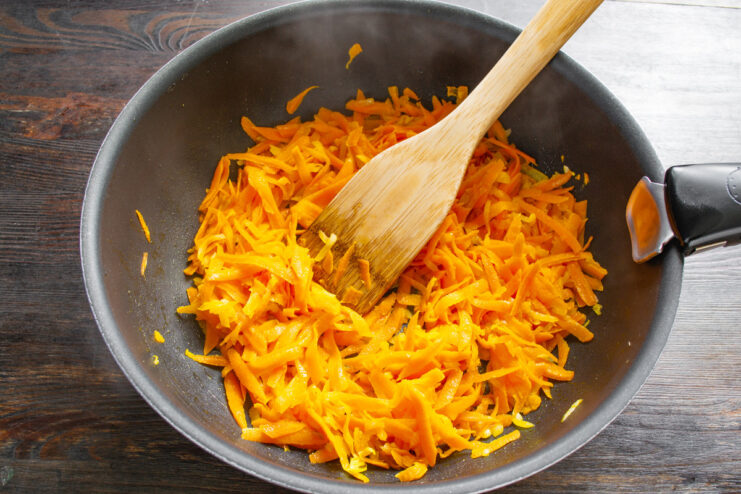Grating a Carrot for the Stuffed Pepper Filling A carrot being grated on a box grater.