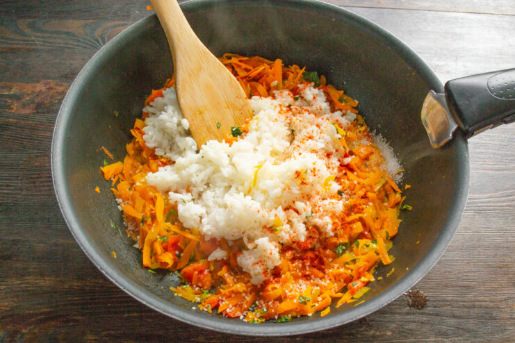 Combining Parboiled Rice with Vegetables for the Stuffing Adding parboiled rice to the cooked vegetable mixture in a skillet.