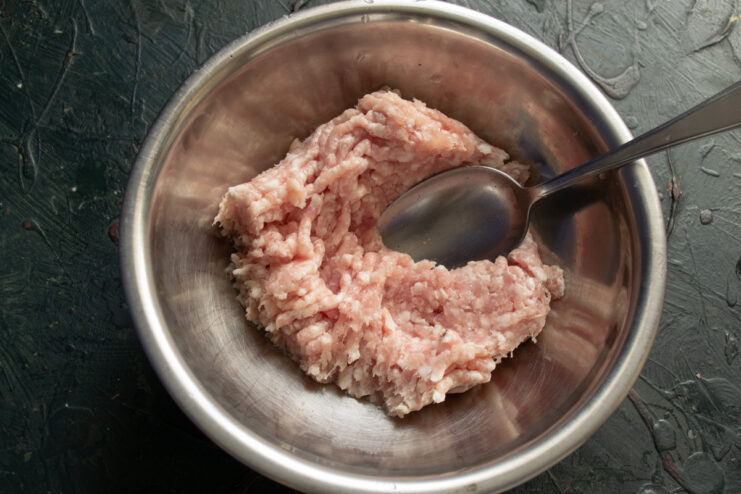 Starting the Filling with Chilled Minced Meat A bowl of chilled minced meat, the base for the stuffed pepper filling.