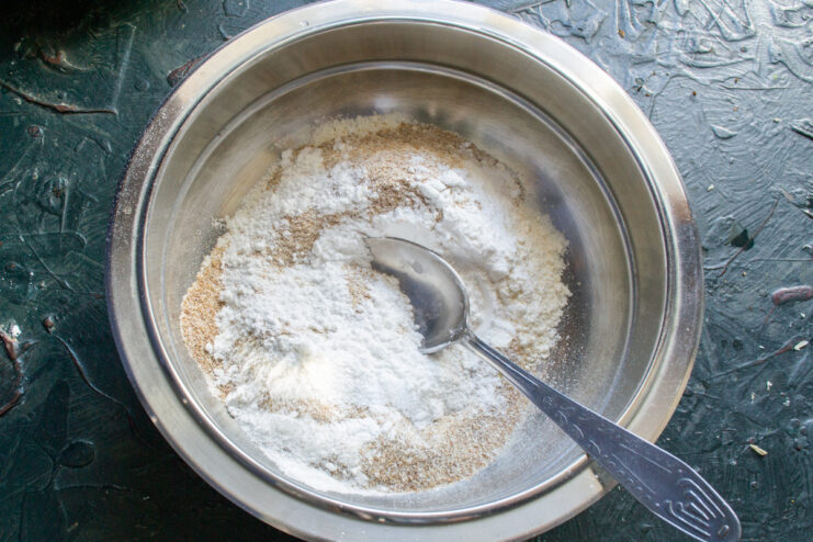 Adding Sweetness to the Dough with Powdered Sugar Powdered sugar being added to the flour mixture in a bowl.