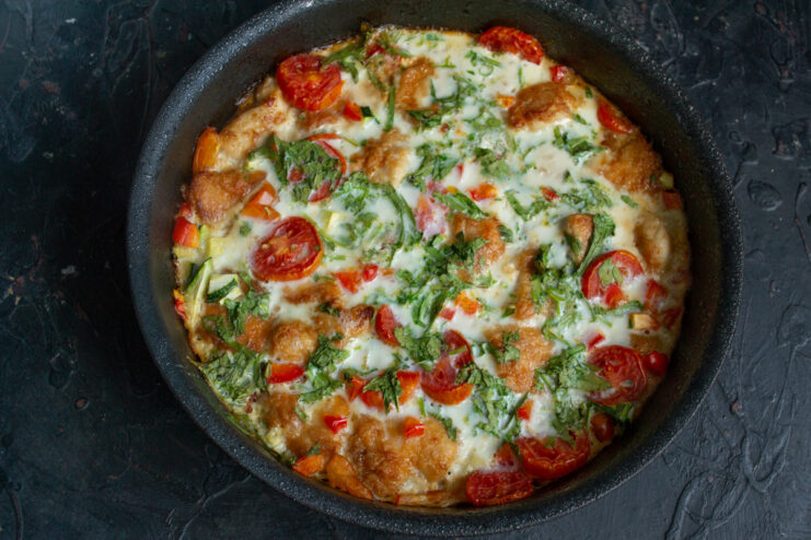 An oven-safe skillet with the frittata mixture going into a hot oven.