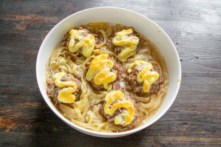 Baking the Pasta Nests Until Golden and Bubbly A close-up of the baked pasta nests in the oven, with golden-brown melted cheese.