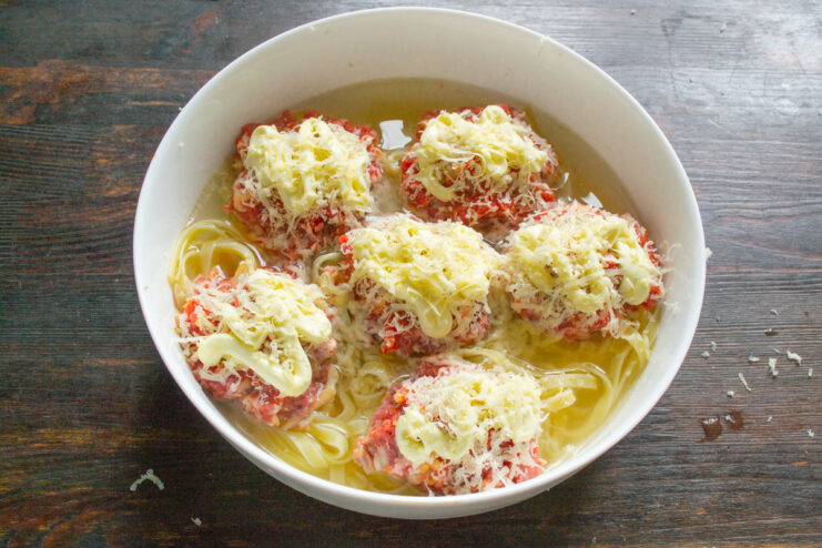 Adding a Swirl of Mayonnaise for Extra Creaminess Squeezing a swirl of mayonnaise onto the cheese-topped meat patties in the pasta nests.