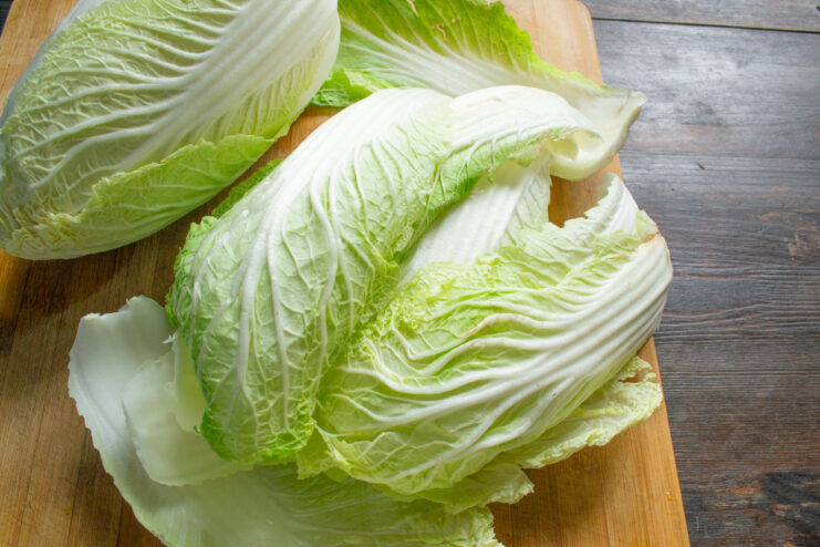 How to Prepare Napa Cabbage Leaves for Rolling A person separating leaves from a head of Napa cabbage for making cabbage rolls.