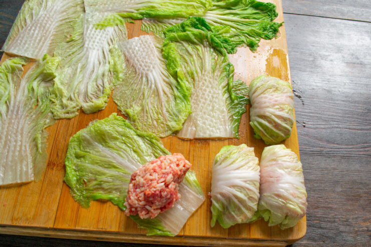 Adding the Filling to the Cabbage Leaf Placing a portion of the beef and rice filling onto a blanched Napa cabbage leaf.