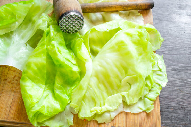 Blanching cabbage leaves to make them pliable for rolling. Cabbage leaves being blanched in a pot of boiling water.