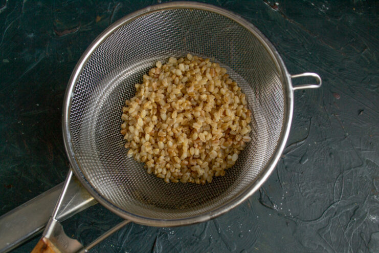 Spelt cooking in a pot on the stove for the golubtsy filling.
