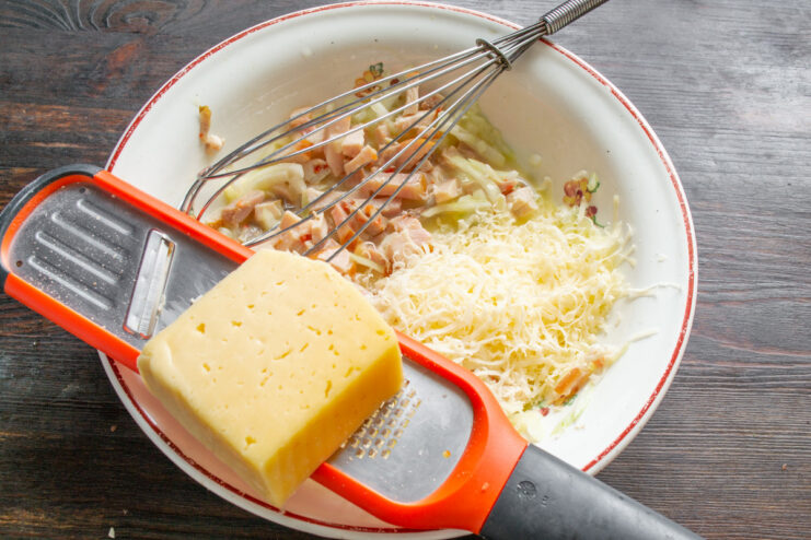 Grating Cheese for the Sandwich Filling Hard cheese being grated into a bowl with other filling ingredients.