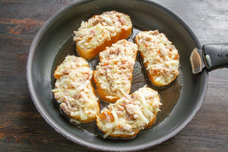 Frying the Sandwiches in a Skillet Sandwiches frying in a skillet, bread side down, turning golden brown.