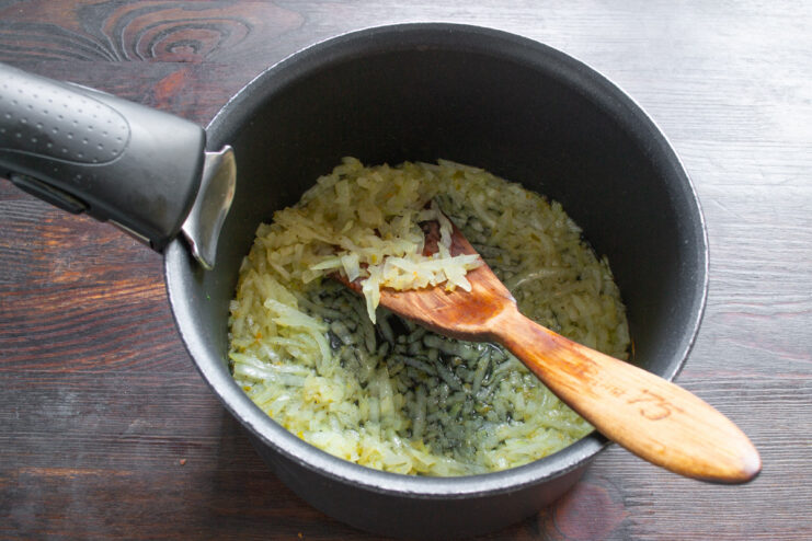 Sautéing Onions in a Pot Chopped onions being sautéed in a heavy-bottomed pot with hot oil.