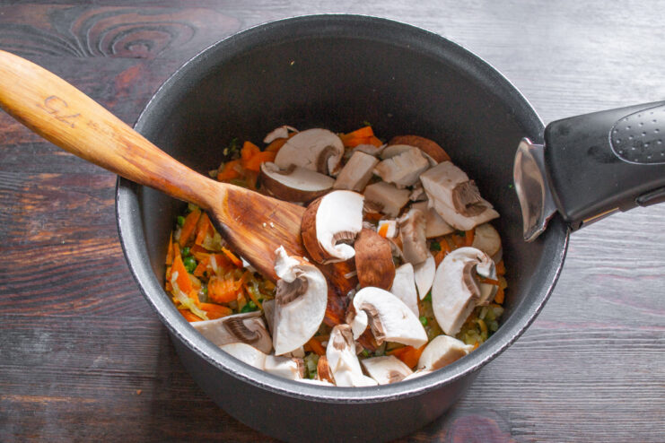 Adding Mushrooms and Mushroom Powder Sliced mushrooms and mushroom powder being added to the pot with vegetables.