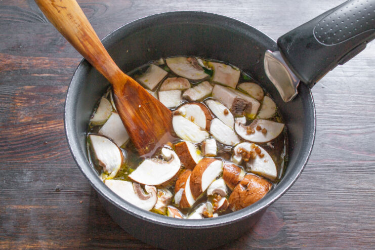 Pouring in Water or Broth Water or broth being poured into the pot with buckwheat and vegetables.