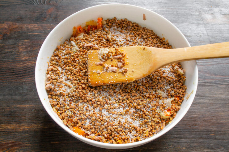Adding the Star Ingredient: Grechka (Buckwheat Groats) Rinsed buckwheat groats (grechka) spread evenly over the chicken in the baking dish.