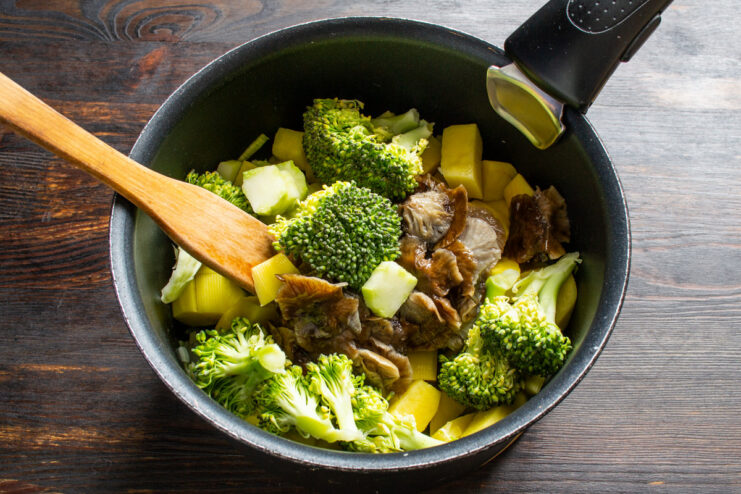 Adding broccoli: Use both the florets and the stem to add texture and nutrients to the soup. Adding fresh broccoli florets and chopped stems to the soup pot with mushrooms and potatoes.