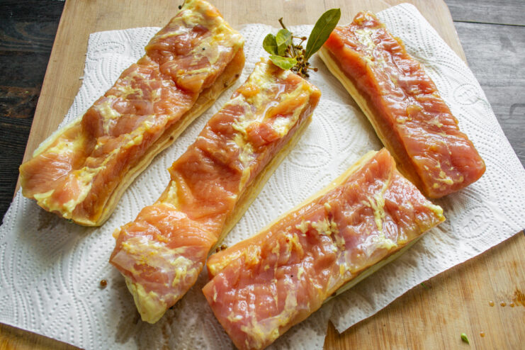 Properly Drying the Pork Belly is a Key Step A piece of golden-colored cured pork belly resting on a paper towel to dry.