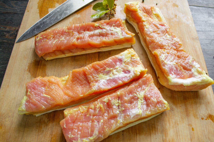 Storing the Plain Cured Pork Belly in the Freezer A large piece of cured pork belly being wrapped in plastic for storage.