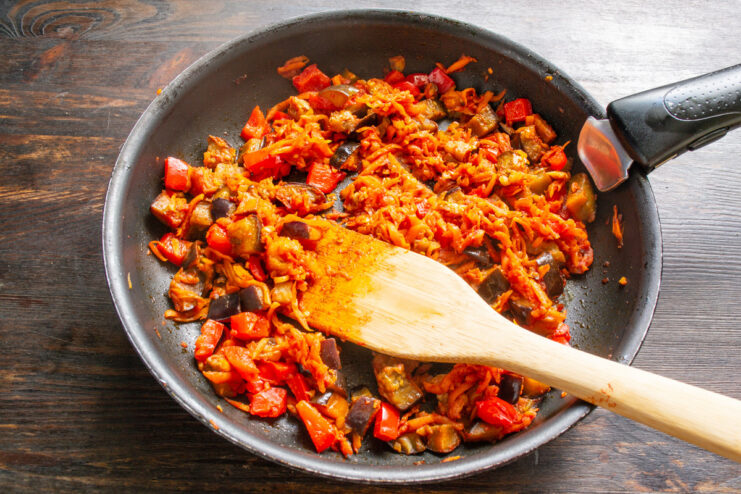 Reducing and Concentrating Flavors - Simmering the vegetables uncovered to thicken the mixture. Vegetable mixture for eggplant caviar simmering uncovered in a skillet.