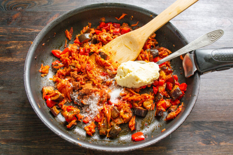 The Secret to Creaminess - Adding rich, full-fat mayonnaise for a smooth texture. A dollop of mayonnaise being added to the cooked vegetables in the skillet.