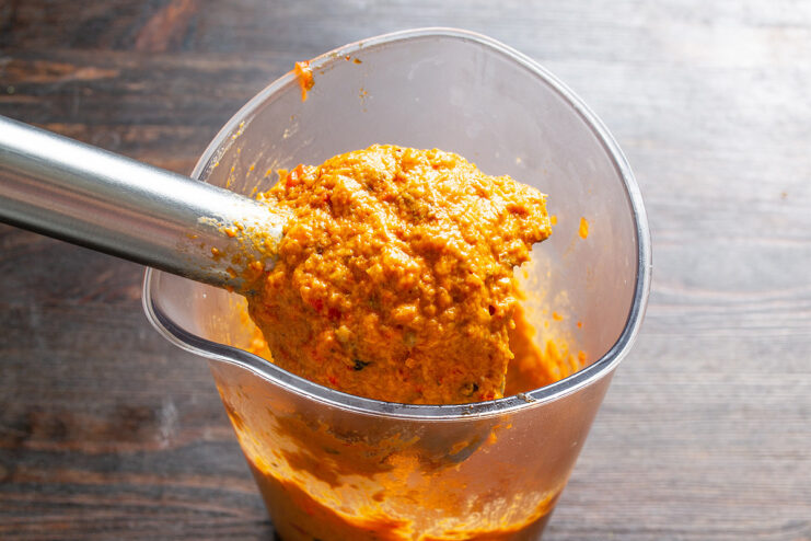 Blending to Perfection - Transferring the cooked vegetables to a blender for a smooth finish. Cooked vegetable mixture being transferred from a skillet to a blender.