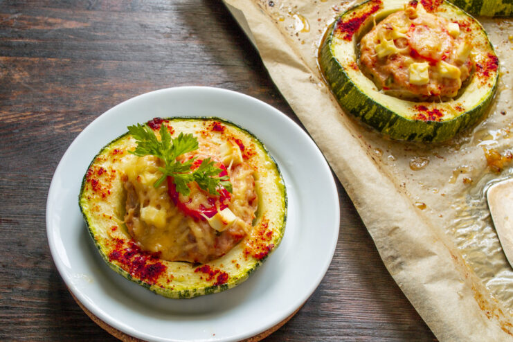 Serving the freshly baked stuffed zucchini. A spatula lifting a perfectly baked stuffed zucchini ring from a baking sheet.