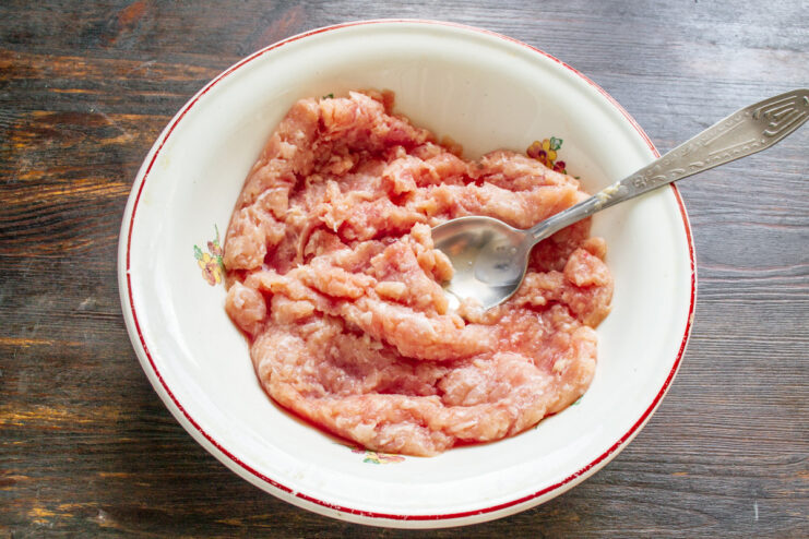 Choosing the best minced meat for the zucchini filling. A bowl of fresh lean minced meat ready to be seasoned for the filling.