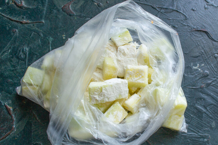 How to Prepare Zucchini for Soup Peeled zucchini being diced into small cubes on a cutting board.