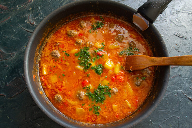Finishing the Soup with Fresh Herbs Adding freshly chopped parsley to the zucchini and meatball soup.