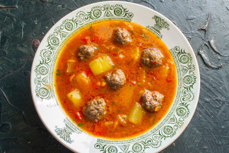 Enjoy a Hearty Bowl of Zucchini Meatball Soup A bowl of zucchini soup with meatballs, served hot and ready to eat.