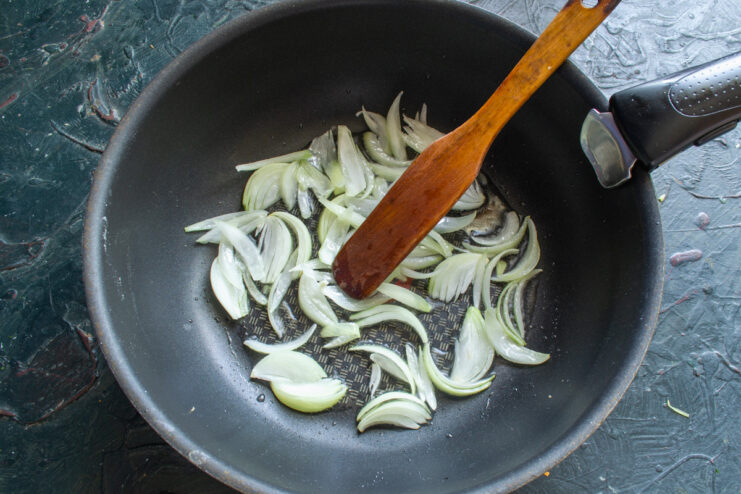 Sautéing Onions to Build Flavor Chopped onions being sautéed in a hot pan with oil.