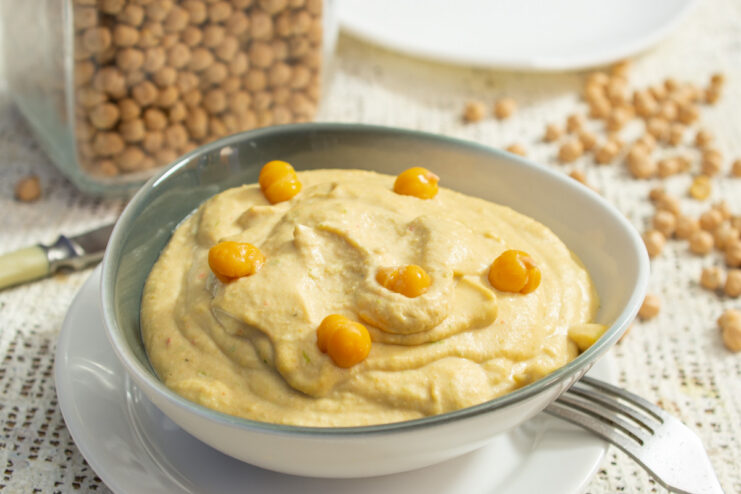 A bowl of creamy homemade hummus, garnished with olive oil and spices, ready to be served.