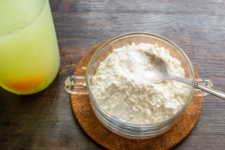 Mixing the dry ingredients before adding them to the bottle. A bowl of flour with baking soda, salt, and sugar being mixed in.