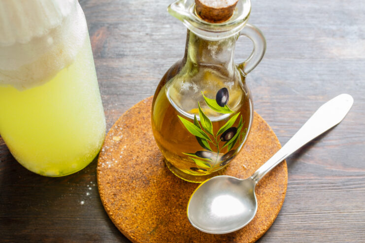 Adding oil to the batter for tender pancakes. Pouring olive oil into the plastic bottle with the other batter ingredients.