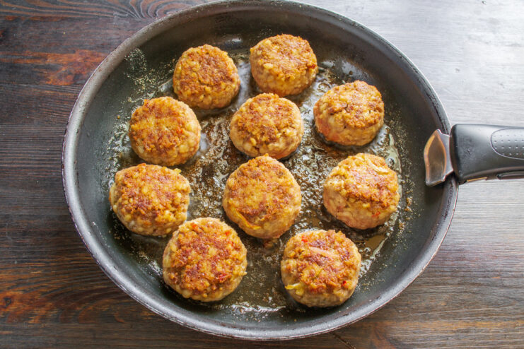 Pan-Frying Meatballs to Golden Perfection Meatballs being pan-fried in a skillet until they are golden brown on all sides.