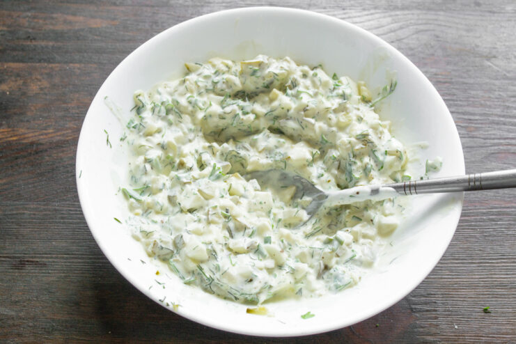 The Finished Creamy and Tangy Sauce Ready for Serving A bowl of freshly mixed creamy sauce with herbs, egg, and pickle.
