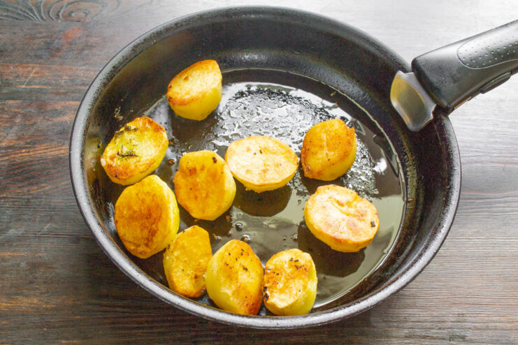 Frying Potatoes to a Perfect Golden-Brown Crisp Potatoes frying in a skillet, developing a golden-brown crust.