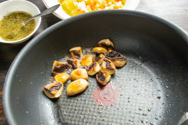 Sautéing Mushrooms Until Golden Brown Sliced mushrooms being sautéed in a hot pan.