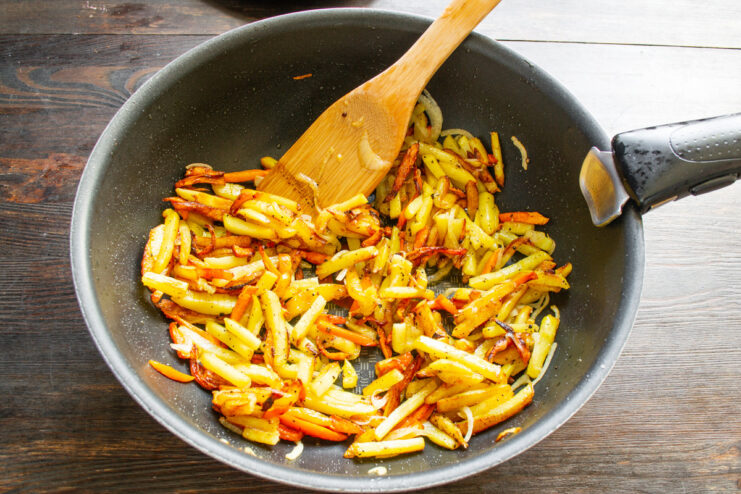 Final Step: The Perfectly Cooked Fried Potatoes are Ready A skillet full of golden-brown fried potatoes, carrots, and onions, ready to be served.