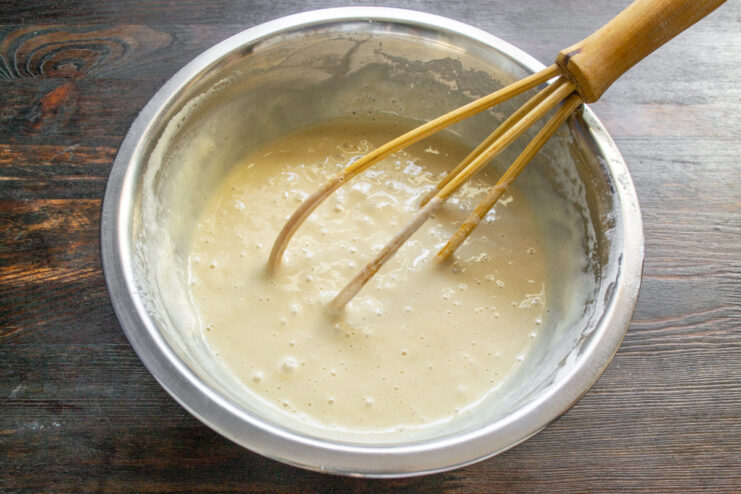 Step 4: Combining wet and dry ingredients to form the batter. Pouring the wet ingredient mixture into the bowl with dry ingredients.