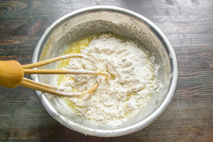 Sifting flour and baking powder for a light muffin texture Sifting flour mixture into the bowl of wet ingredients.