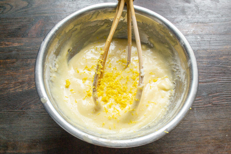 Adding fresh lemon zest for a bright, citrusy flavor Grating fresh lemon zest into the muffin batter.