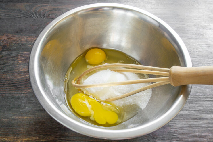 Step 1: Combining eggs and sugar for the cupcake batter A glass bowl with two eggs and granulated sugar, ready for mixing.