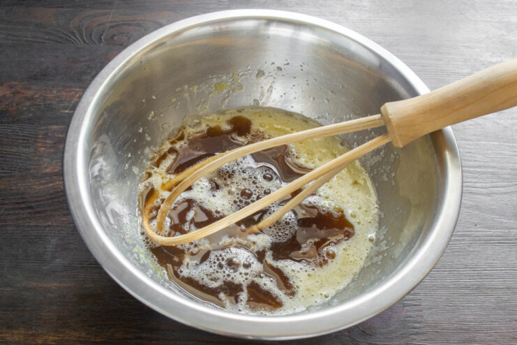 Step 2: Adding Coca-Cola to the cupcake batter Pouring Coca-Cola into a bowl with the egg and sugar mixture.